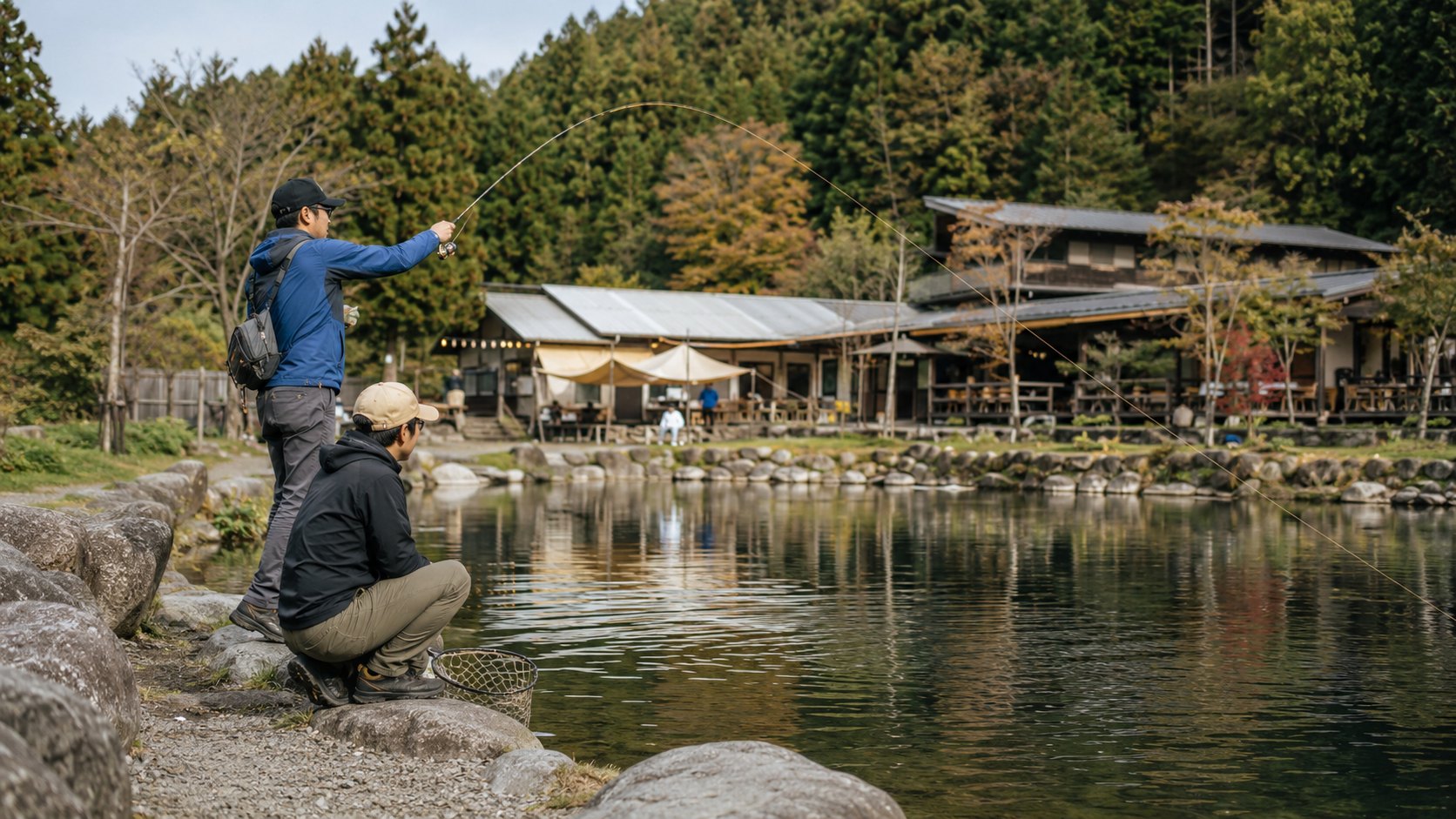 管理釣り場でキャストするアングラーとネットを構える仲間