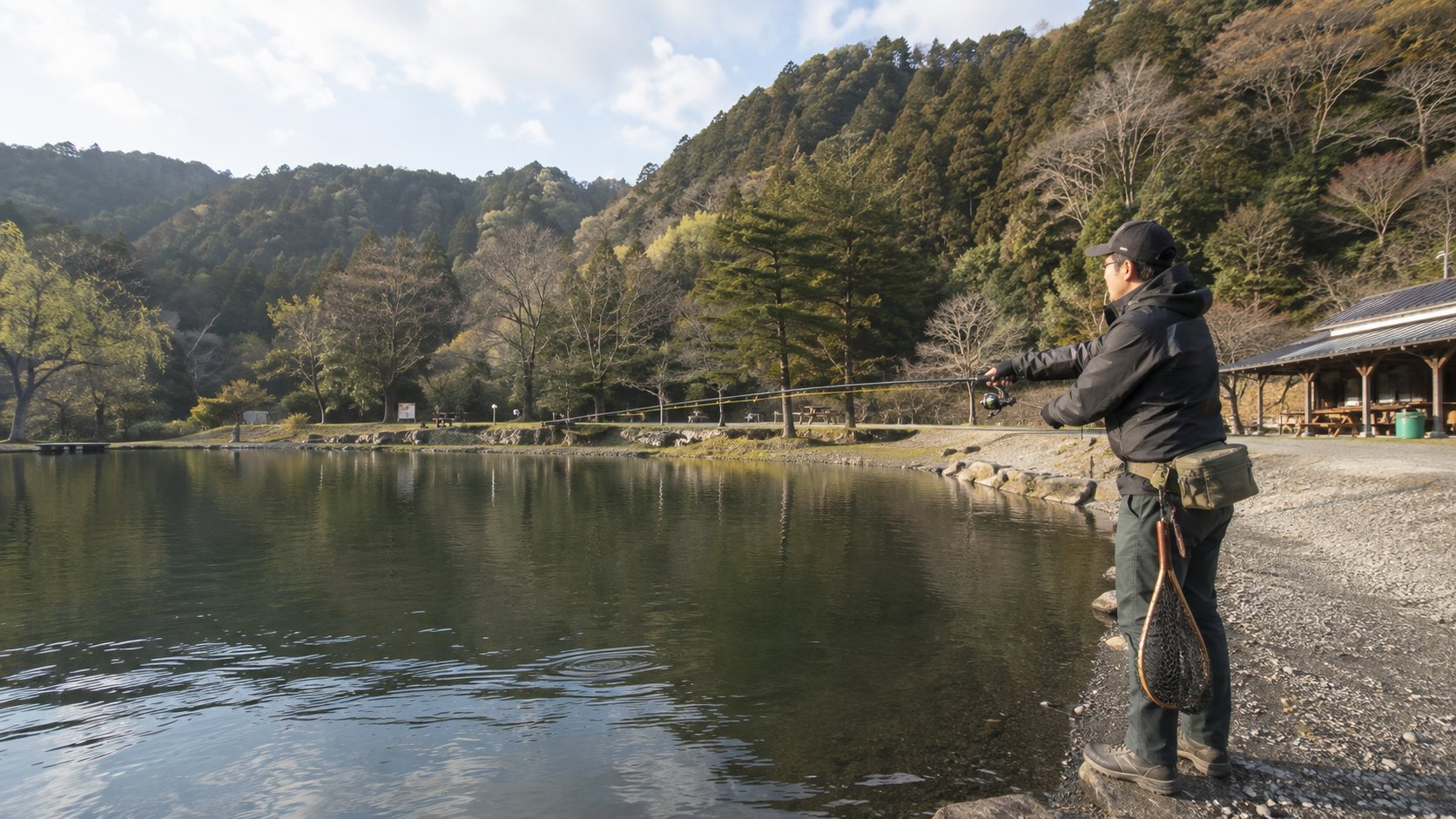 山あいの管理釣り場でキャストするアングラー